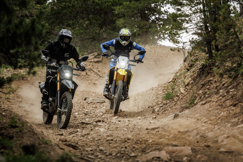 Zwei Motorradfahrer auf Offroad-Strecke, die Staub aufwirbeln und die Natur genießen.