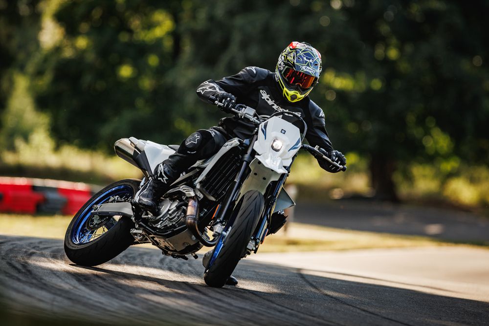 Ein Motorradfahrer in Schutzkleidung fährt auf einer Rennstrecke mit einer sportlichen Maschine und zeigt beeindruckende Fahrtechnik.