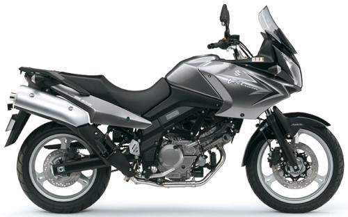 Das Bild zeigt ein silbernes Suzuki V-Strom Motorrad in Seitenansicht, ideal für Abenteuer und lange Fahrten.